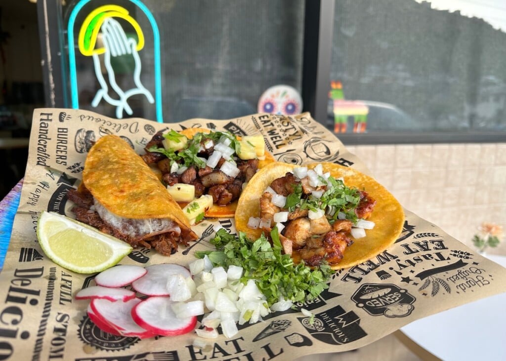 three tacos and fixings on printed takeout wrapper