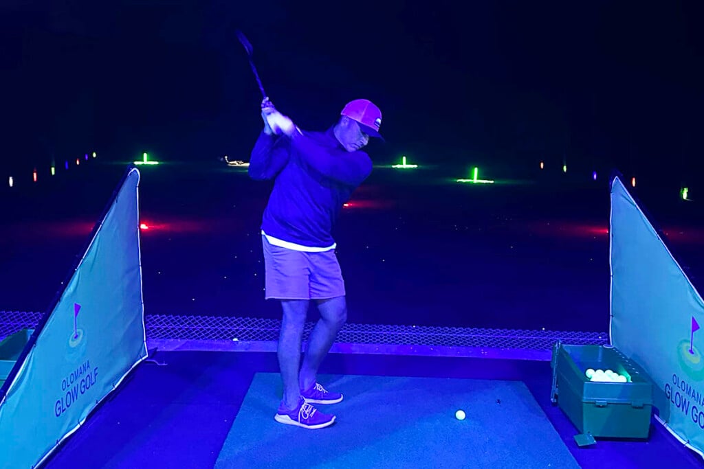 golfer at driving range hitting glowing golf ball