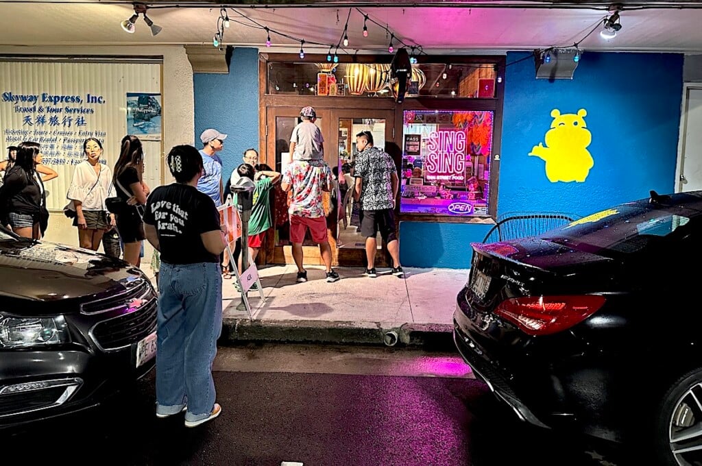 passersby looking into Singsing Thai Restaurant