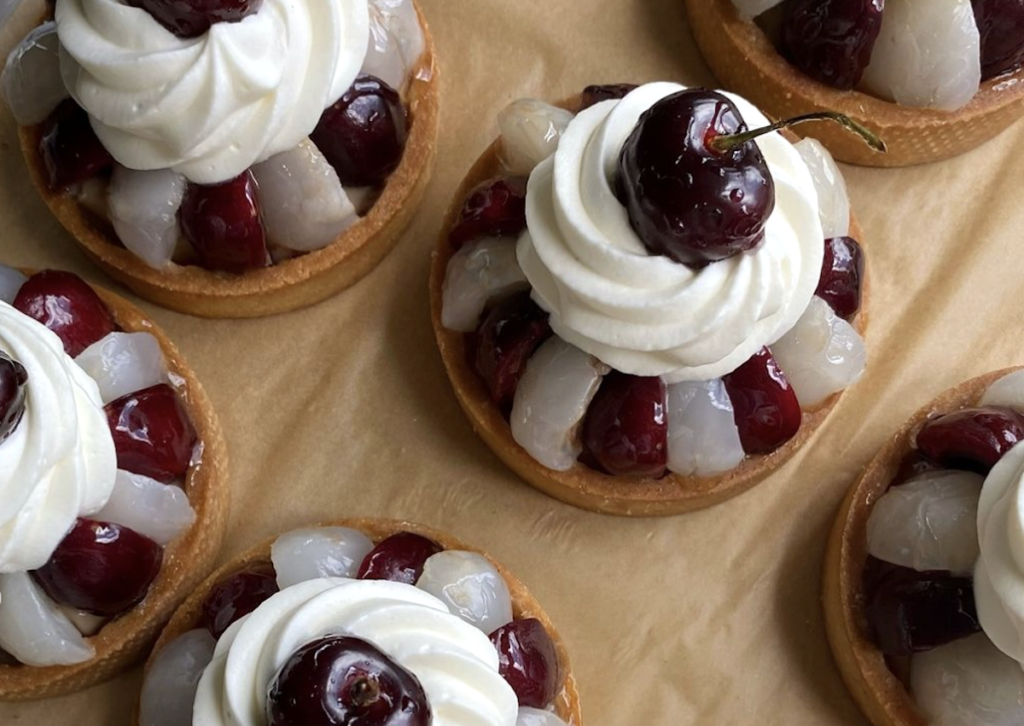 cherry and lychee tarts decorated with whipped cream